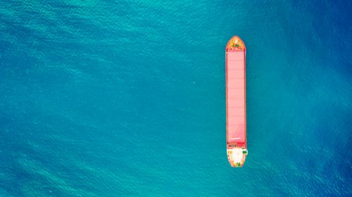 container-ship-export-import-business-logistics-shipping-cargo-harbor-water-transport-international-aerial-view-azure-sea-water-vertical-image-red-container-boat-copy-space